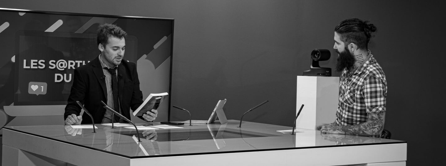 a man in a suit and tie is LMtv Sarthe Aurélien Cailloce itting at a desk with a laptop