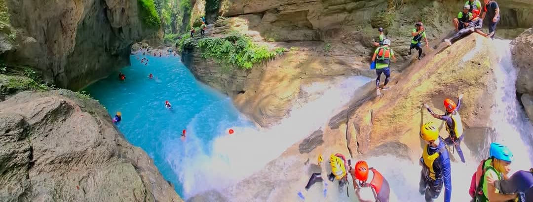 several group of people in helmets canyoneering