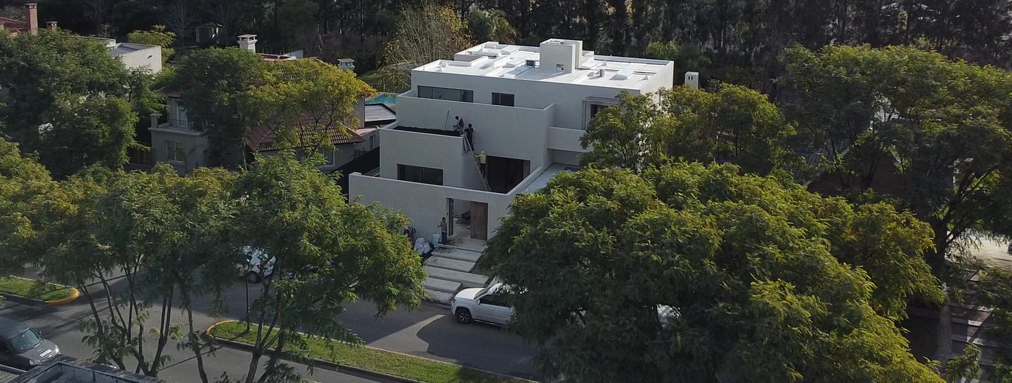 a large white house with a white roof and a car parked in front of it