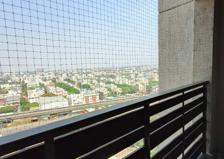 Close-up of a sturdy anti pigeon net installed on a balcony in Kodambakkam.