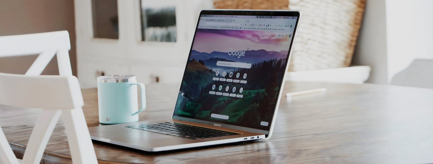 Un ordinateur portable ouvert sur une table avec une tasse de café