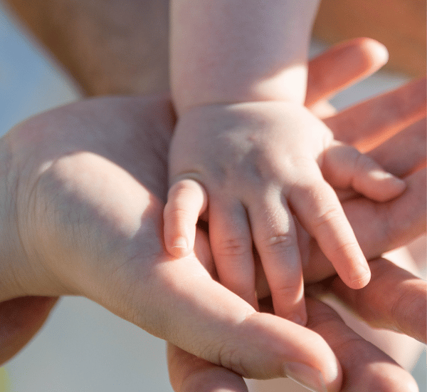 parents holding baby's hand