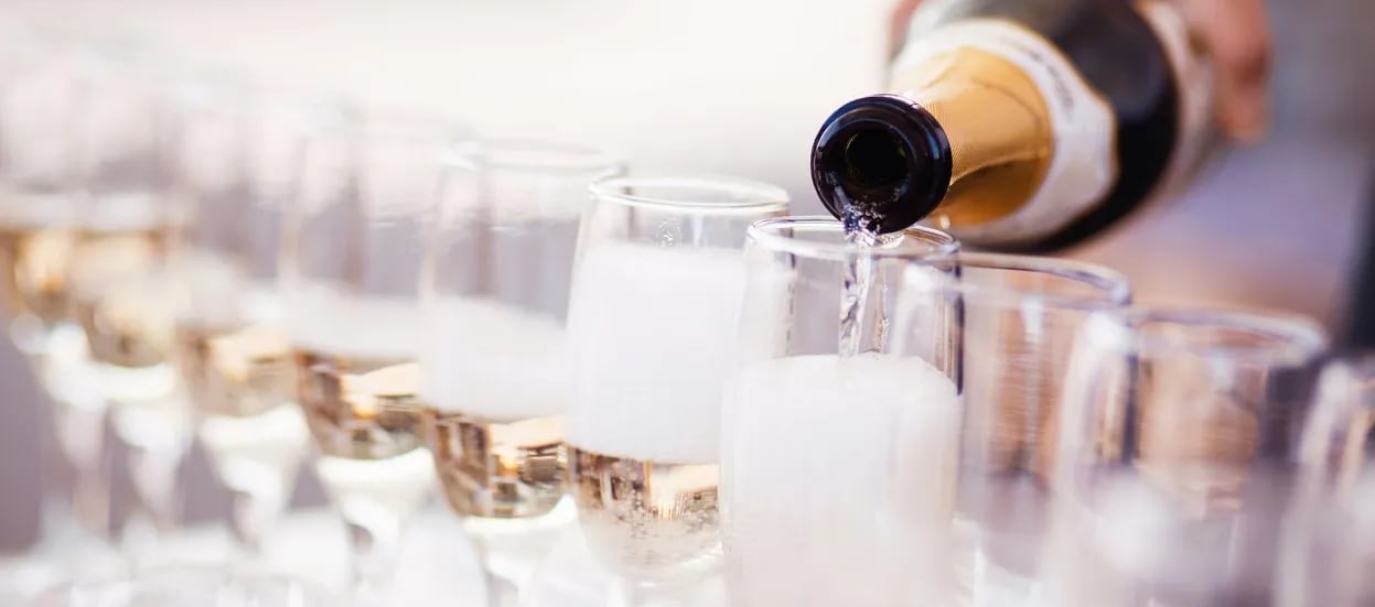 Bartender pouring champagne into flutes in preparing for a wedding toast - Premier Event Staffing