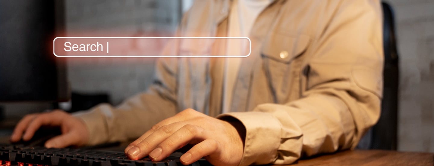 a man sitting at a desk with a keyboard and a keyboard