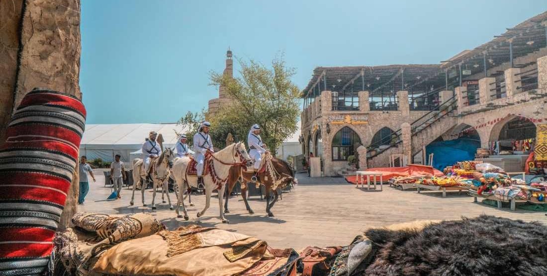 a group of people riding horses in a town