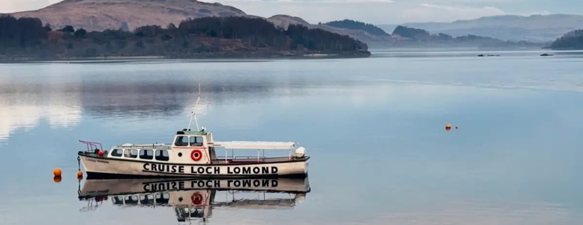white boat on Loch Lomond with hills in the background