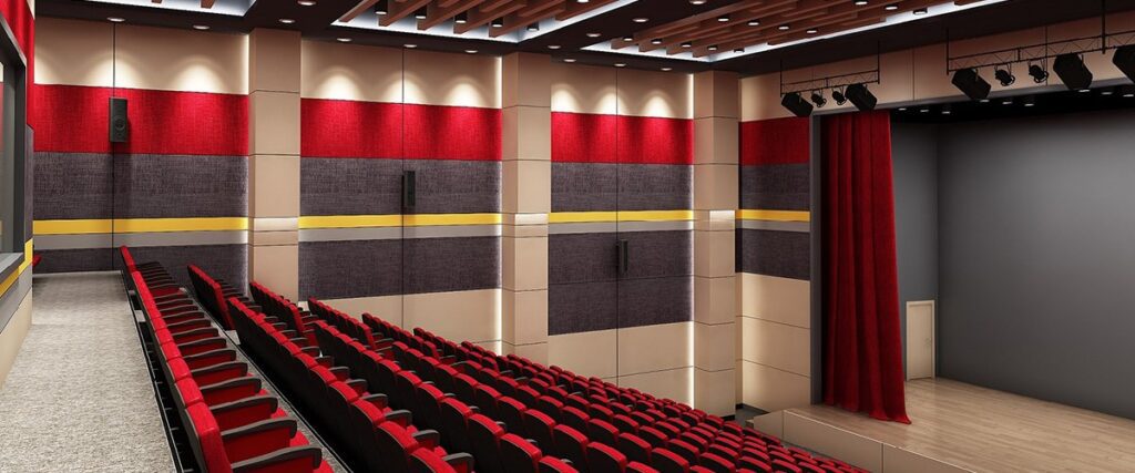 a theater room with rows of red seats and red curtains