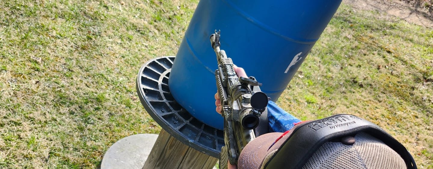 Man engaging targets from a barrier using self-defense firearm during training.