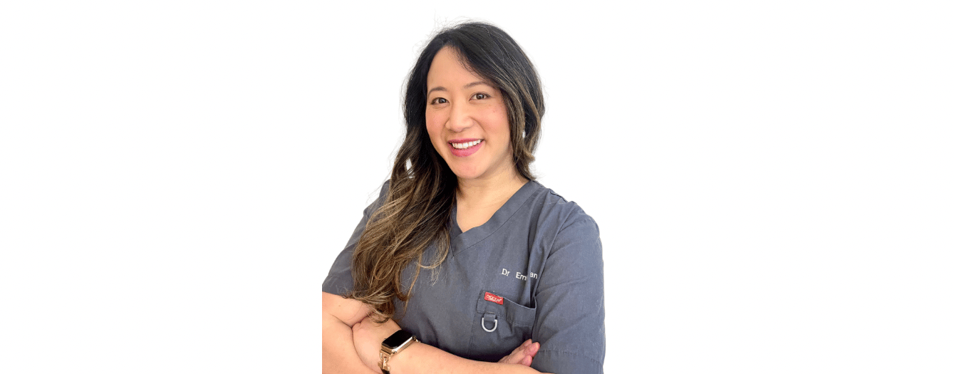 a woman in a grey scrubs with an inviting smile