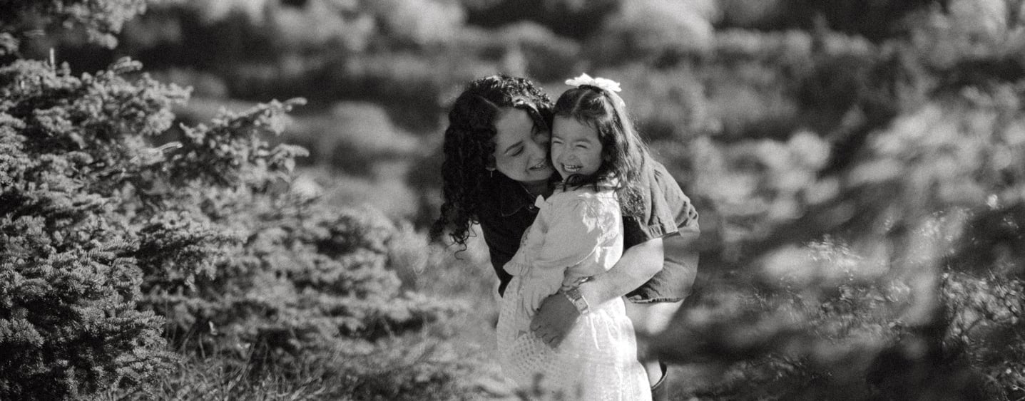 a woman in a white dress is holding a child