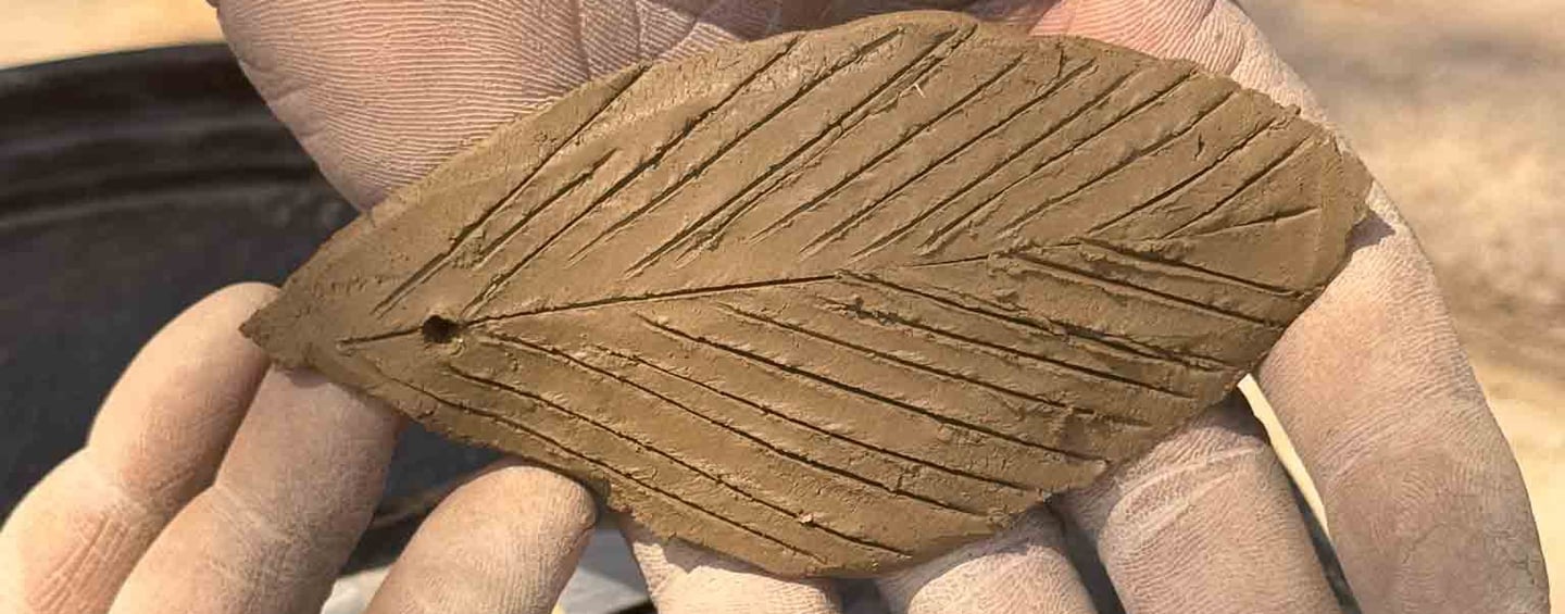 close up picture of a man holding a clay leaf