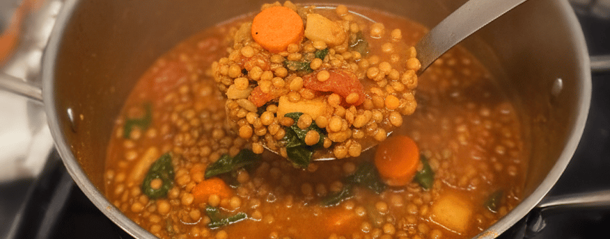 Lentilles vertes au chorizo épicé et carottes servies dans une assiette creuse.