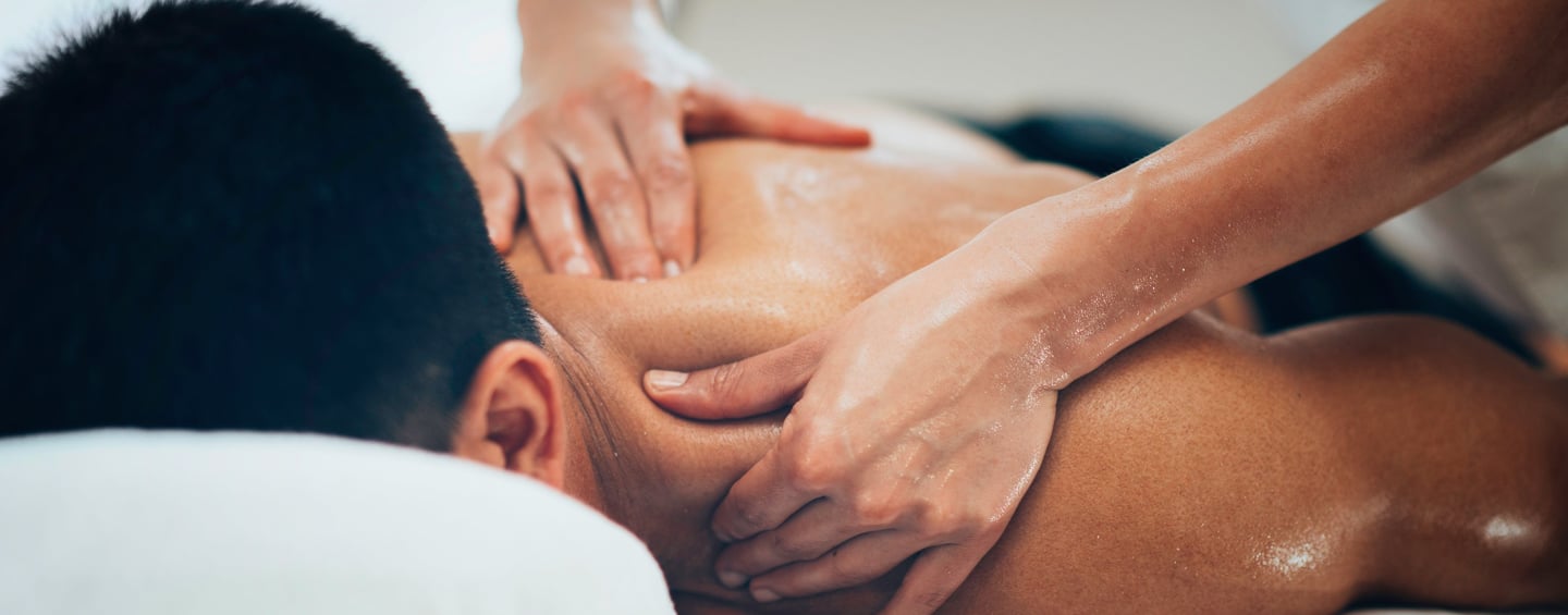 Massage therapist applying firm pressure during a therapeutic back massage