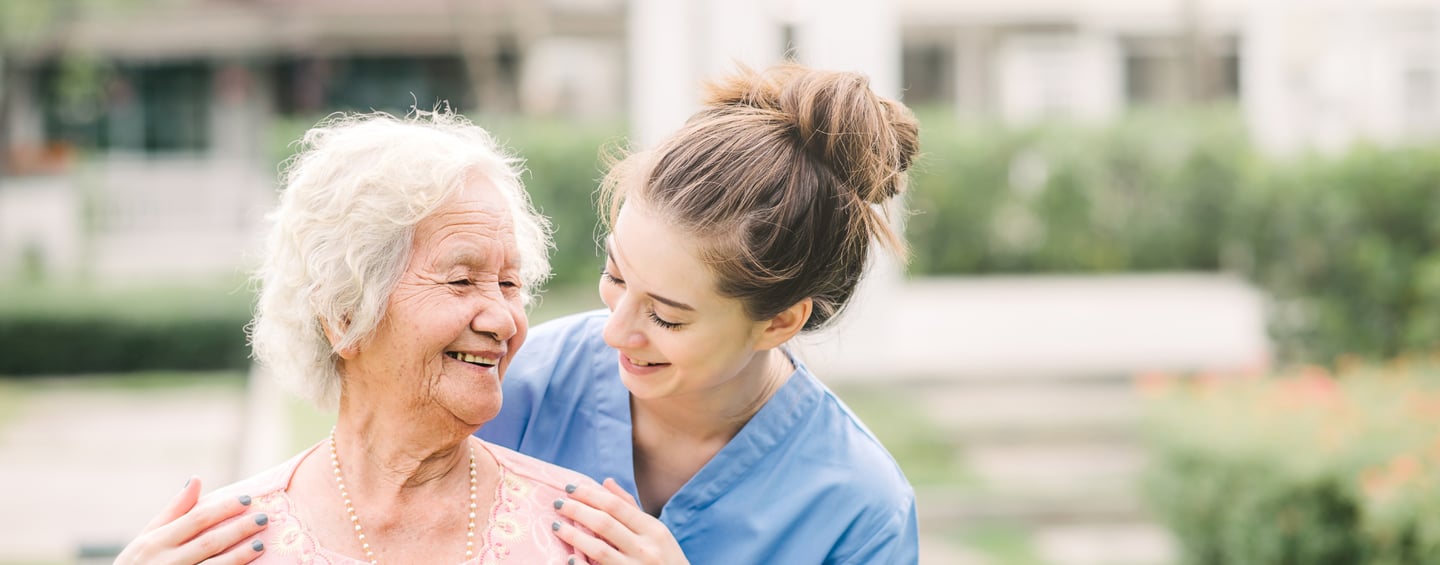 Caregiver smiling with an elderly woman 