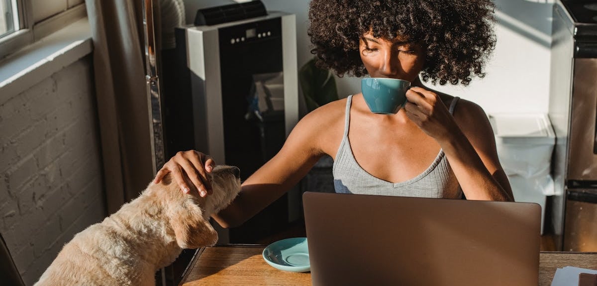 woman sitting with her dog and reading about why professional grooming is essential for pets in Duba