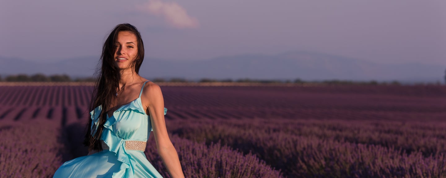 a woman in a blue dress standing in a lavender field
