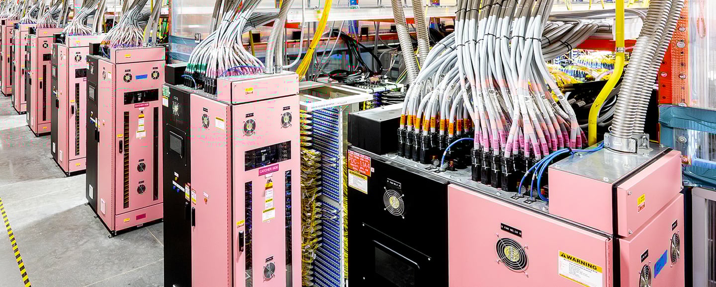 Industrial server racks with organized high-voltage power cables in a modern data center facility.