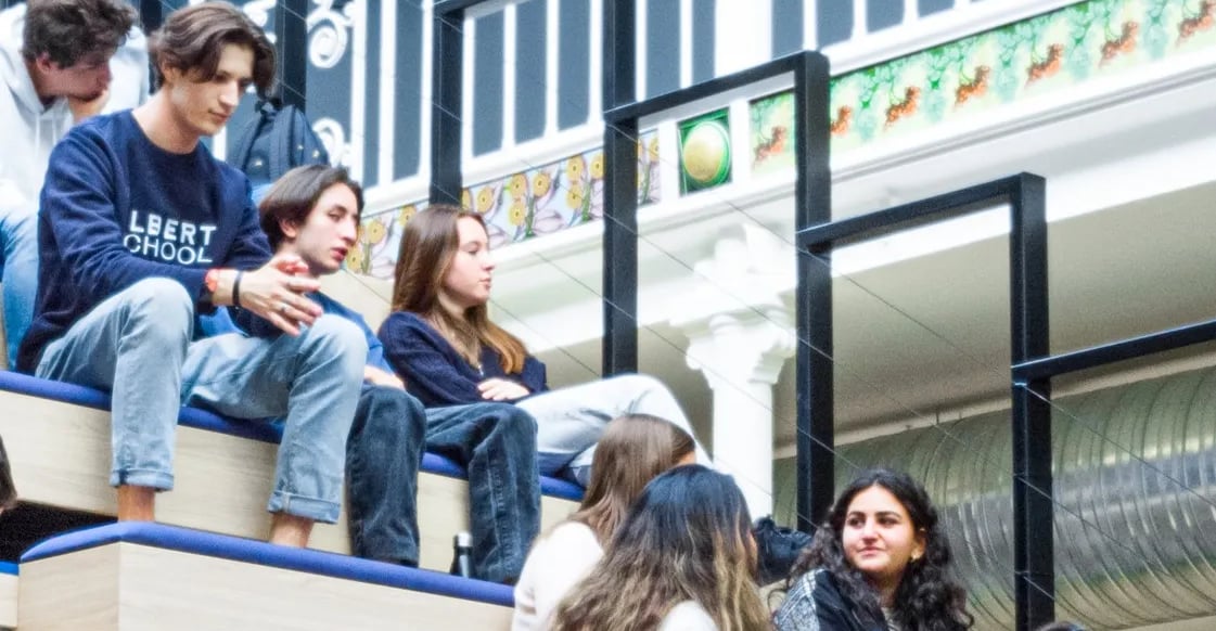 a group of people sitting on a bench in Albert School