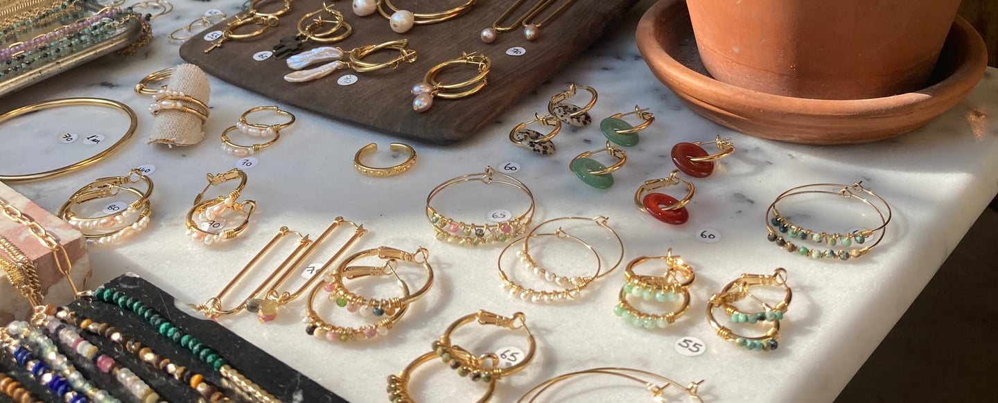 a table with a lot of jewelry and a potted plant