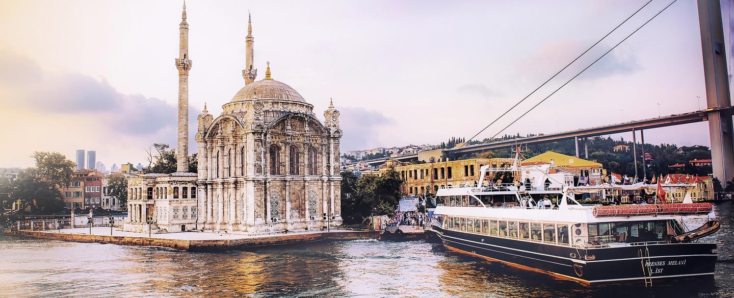 Ortaköy Mosque and a boat on the Bosphorus with the Bosphorus Bridge in Istanbul.