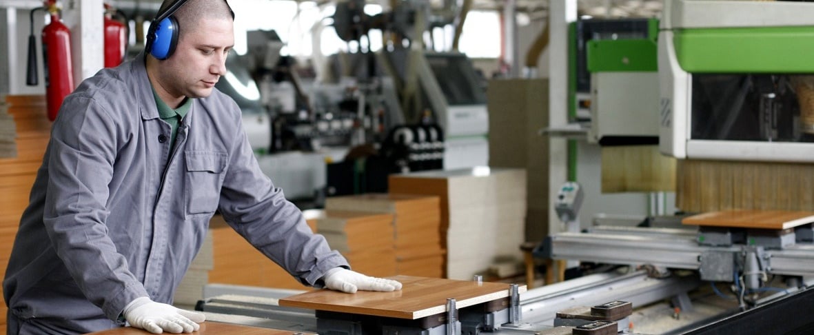 a man in a gray jacket and headphones on a machine