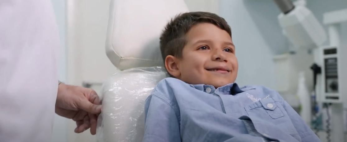 a young boy sitting in a chair in a hospital