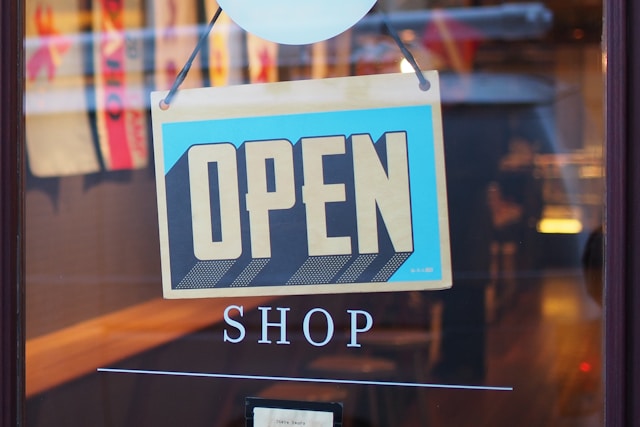 a sign that says open shop, business formation lawyer
