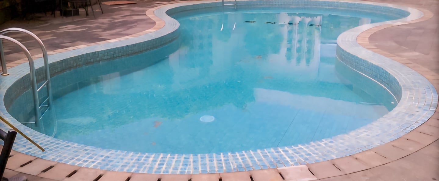 Kolam renang minimalis dengan keramik biru muda.