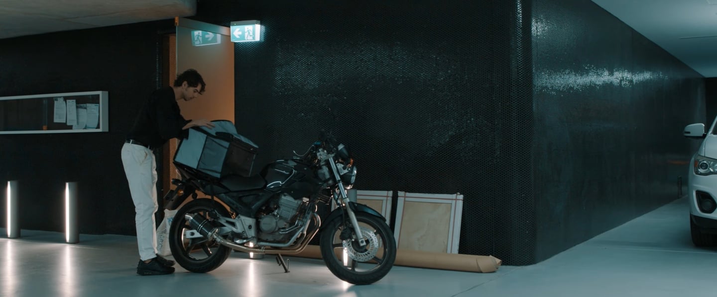 a man standing next to a motorcycle in a garage