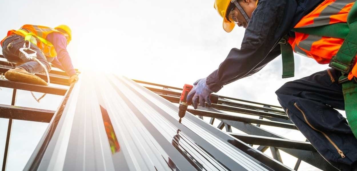 a group of workers working on a metal roof
