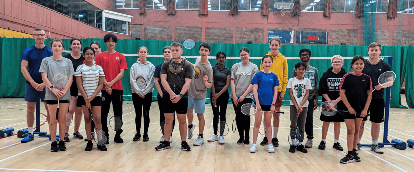 a group of junior badminton players with their coaches