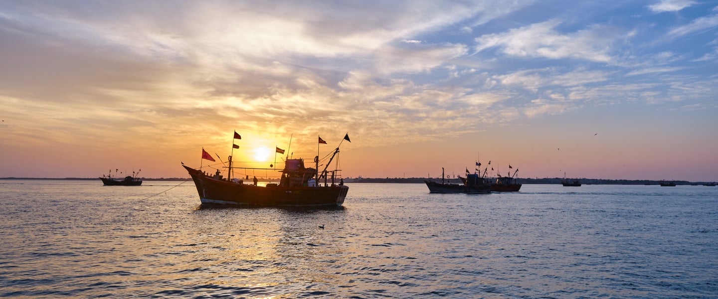 a boat in the water with a sunset in the background