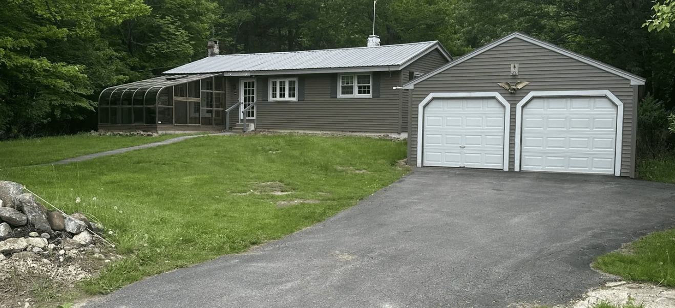 a client's house with a driveway and garage with a garage door