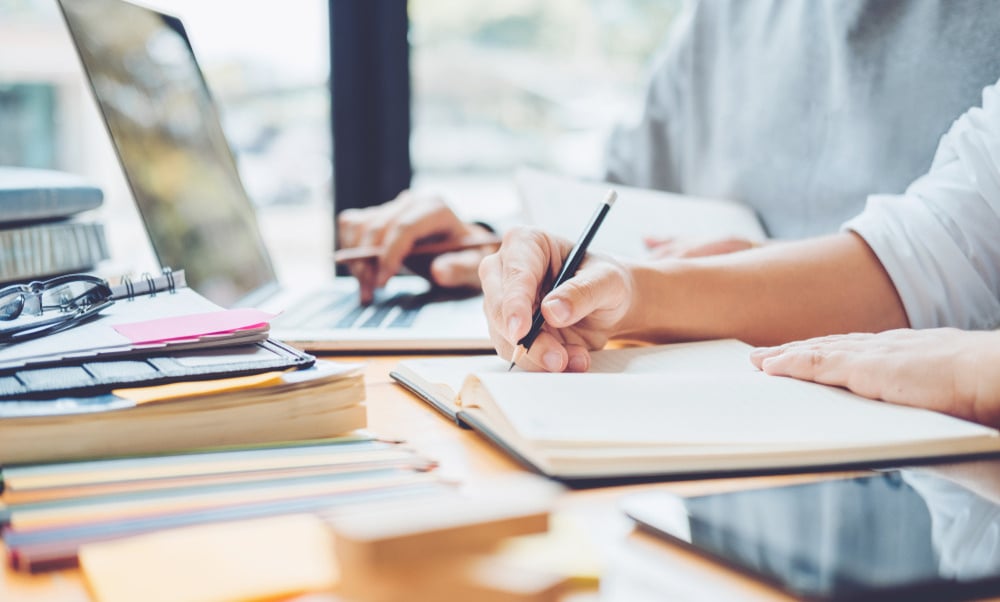 man and woman studying and writing