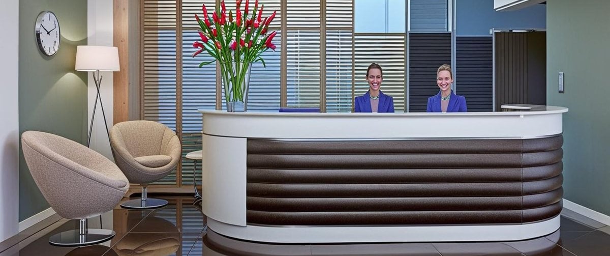 2 staff behind a reception desk