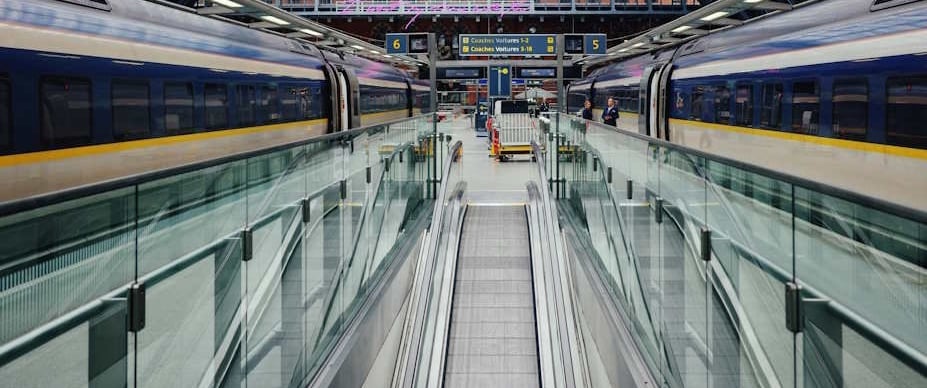 trains waiting on a platform at a large station