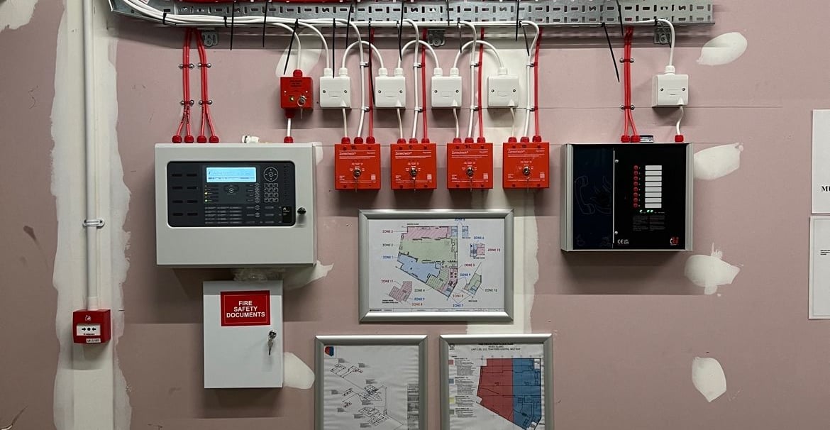 a room with a wall mounted with electrical equipment