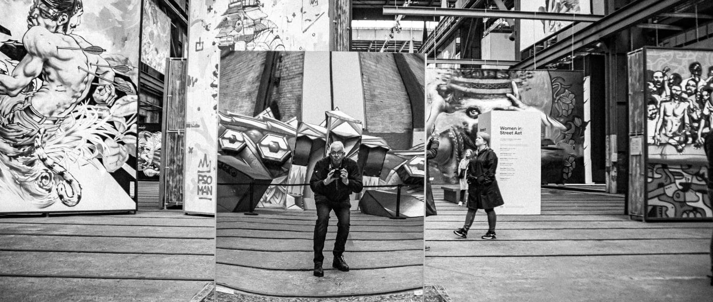 a man standing in front of a large display of art