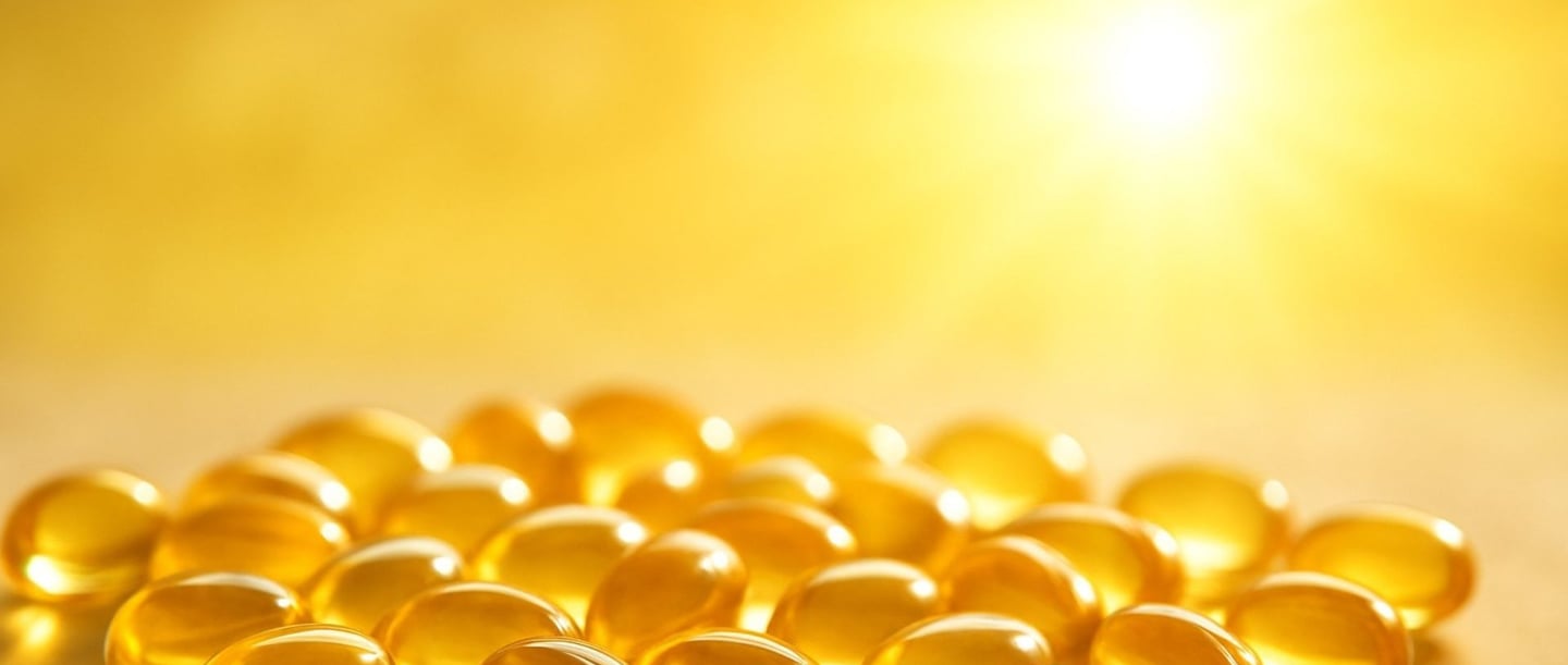 Soft-focus capsules of vitamin D illuminated by sunlight.