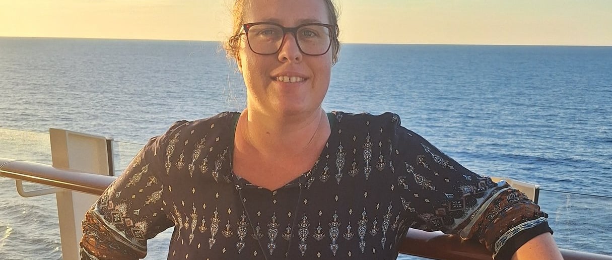Eine Frau steht auf dem Deck eines Kreuzfahrtschiffes