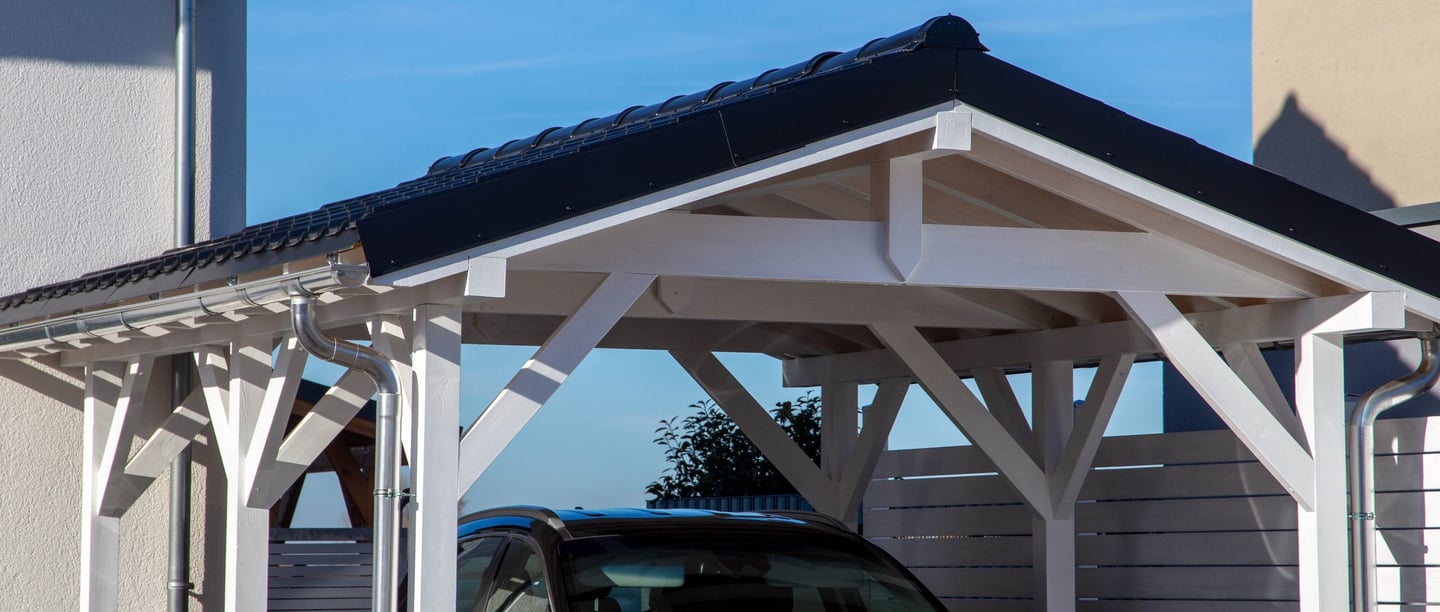 carport en bois peint en blanc avec toiture tuile pour protéger une voiture