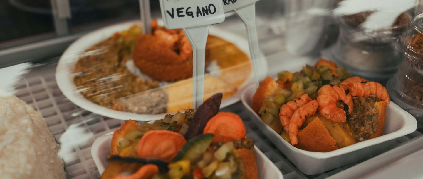 a display case with a variety of food items, acaraje