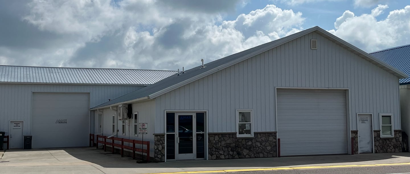 photo of front of building with 2 large garage doors and 2 entry doors