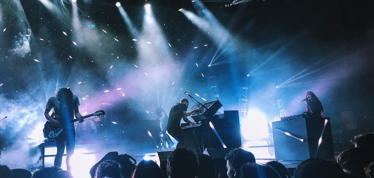 a group of people standing around a stage with a guitar