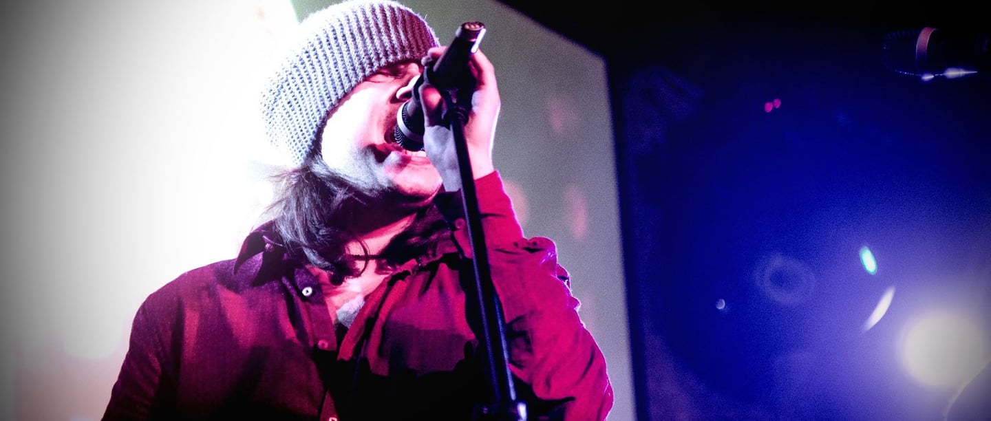 a man in a beanie hat and a microphone