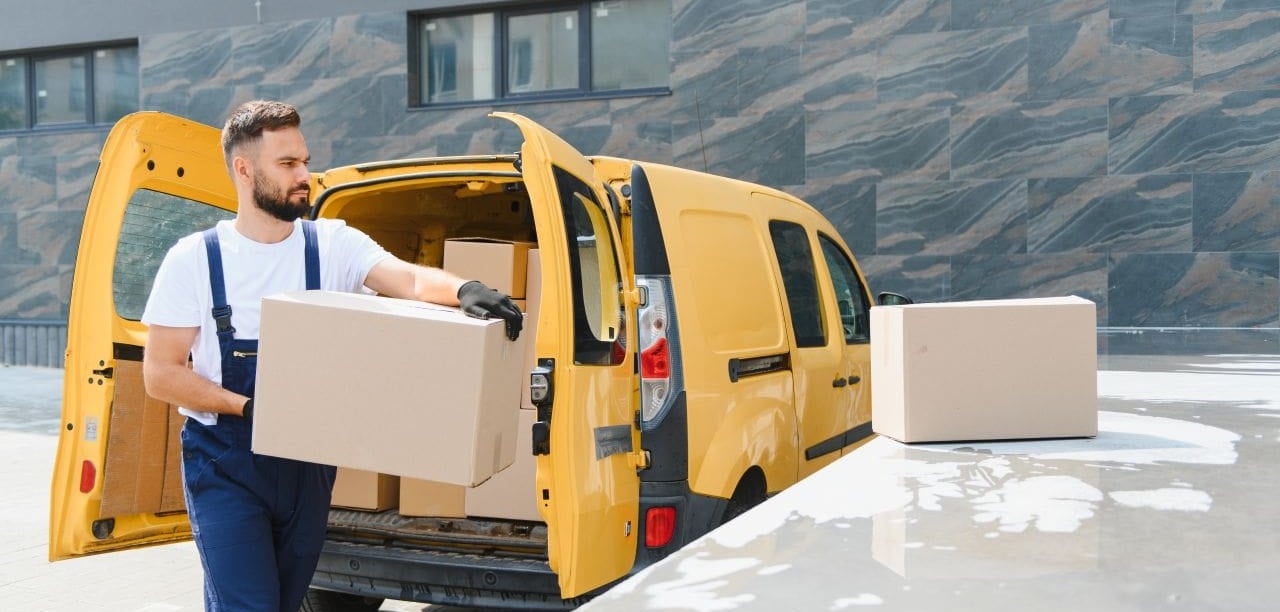 Man carrying box from yellow van