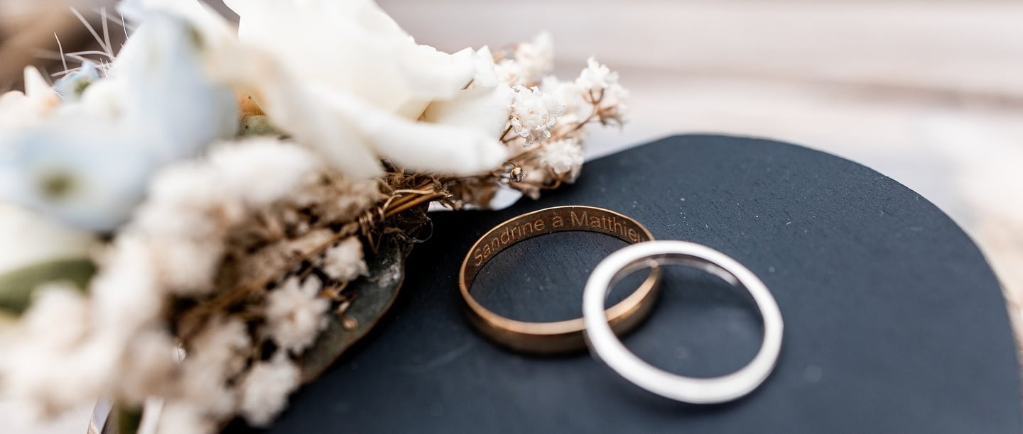 Deux alliances posées l'une sur l'autre près dune composition florale
