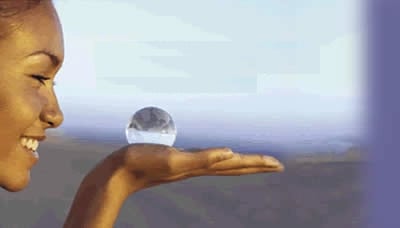 Partie d'un visage de femme. Elle tient dans sa paume de main 1 boule de cristal symbole hypnotique