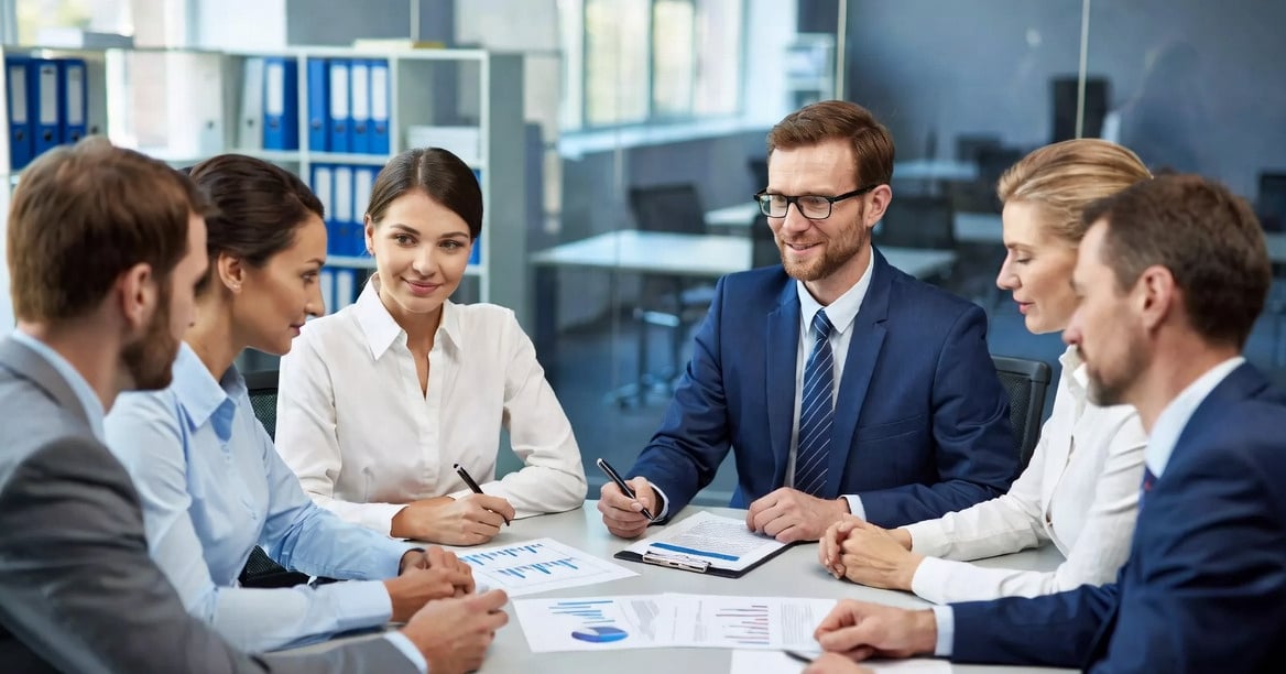 personas reunidas trabajando, dialogando y revisando documentación
