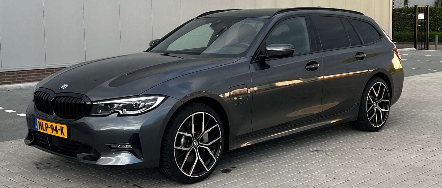 a grey bmw wagon parked on a brick wall